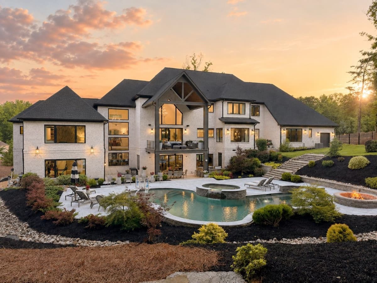 Twilight rear exterior of a luxury estate with a pool